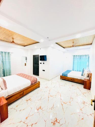 two beds in a large room with marble floors at Hotel Shiva Darshanam in Varanasi