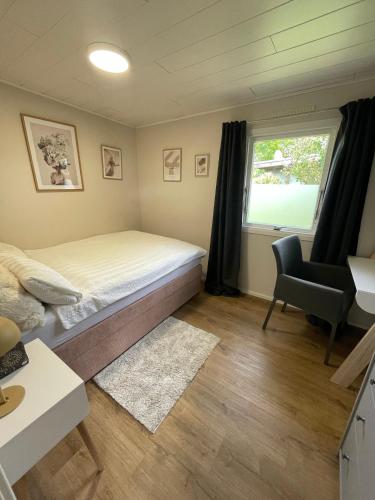 a bedroom with a bed and a chair and a window at Marla zum Strand in Garrel