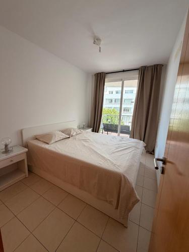 a bedroom with a white bed and a window at relax by the sea in Puerto de Santiago