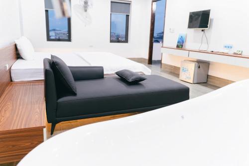 a living room with a couch and a bed at R Hotell in Sầm Sơn