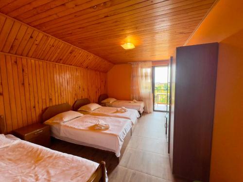 a room with three beds in it with a window at Hotel Kobuleti Garden in Kobuleti