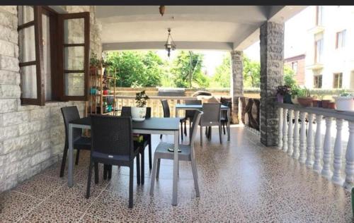 a dining room with a table and chairs on a porch at Hotel Kobuleti Garden in Kobuleti