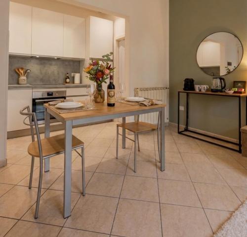 a kitchen with a table with two chairs and a counter at Deluxe Flat Empoli GVARO in Empoli