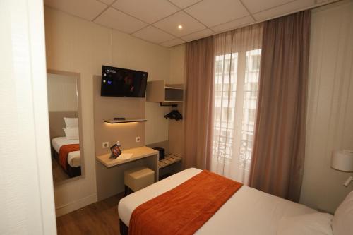 a hotel room with two beds and a mirror at Hôtel Des Trois Gares in Paris