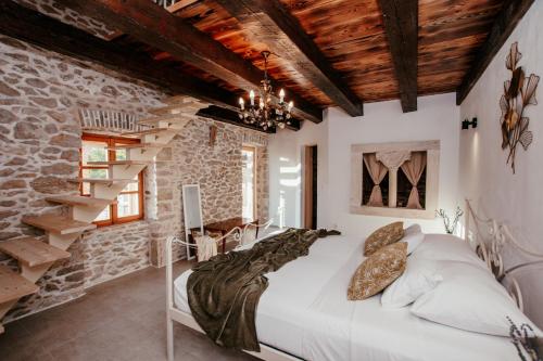 a bedroom with a bed and a stone wall at Villa Romantika Dalmacija in Nin