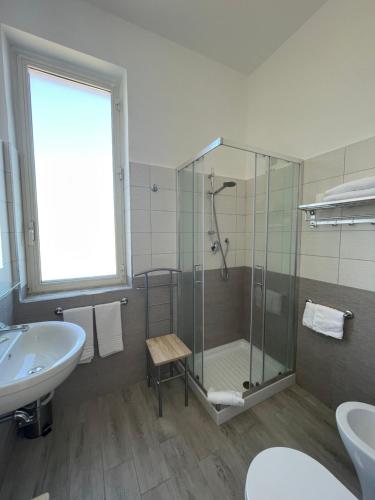 a bathroom with a glass shower and a sink at Hotel Le Najadi in Santa Marinella