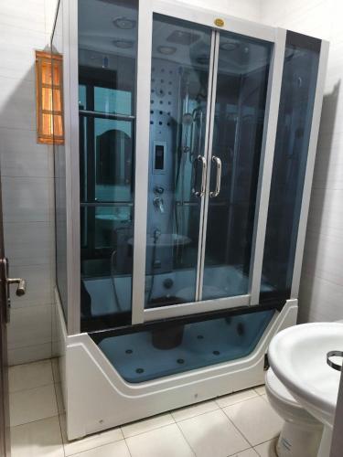 a glass shower in a bathroom with a toilet at Hillmabliz Apartment in Abuja