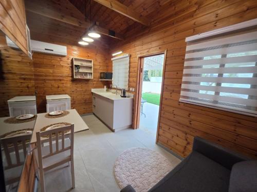 a kitchen with wooden walls and a table and chairs at הבקתות במושבה in Rosh Pinna
