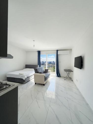 a white room with a bed and a couch at Long Beach Royal Sun Elite Studio with Pool KKTC in Paralimni