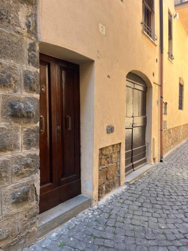 a building with a wooden door on a street at Vicolo in Fiore House in Orvieto