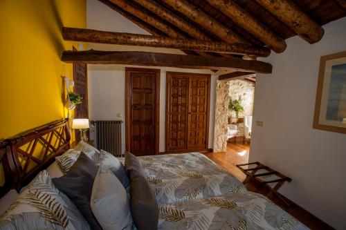 a bedroom with a bed in a room with wooden beams at Hotel Casa Palacio Uclés in Uclés