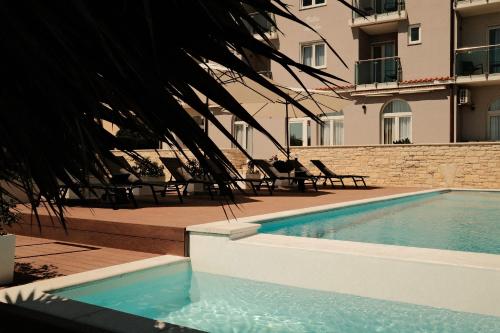 a swimming pool in front of a building at Villa Mirko in Barbariga
