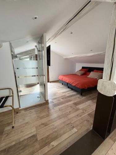 ein Schlafzimmer mit einem roten Bett und einer Glasschiebetür in der Unterkunft Suite Maison Roche in Carpentras