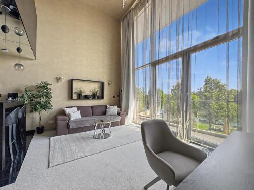 a living room with a couch and a large window at Eurovea Apartments in Bratislava