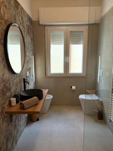 a bathroom with a sink and a toilet and a mirror at LatinaStreet Apartament in Riccione