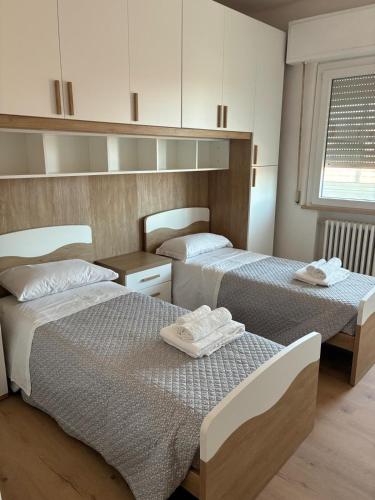 a bedroom with two beds with towels on them at LatinaStreet Apartament in Riccione