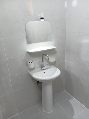 a white bathroom with a sink and a mirror at City Hotel in Luxor