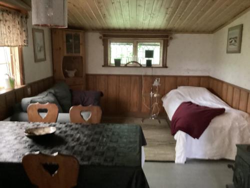a bedroom with a bed and a table and a couch at Västerdala Onwest in Äppelbo