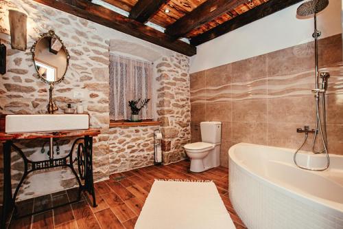 a bathroom with a tub and a toilet and a sink at Villa Romantika Dalmacija in Nin