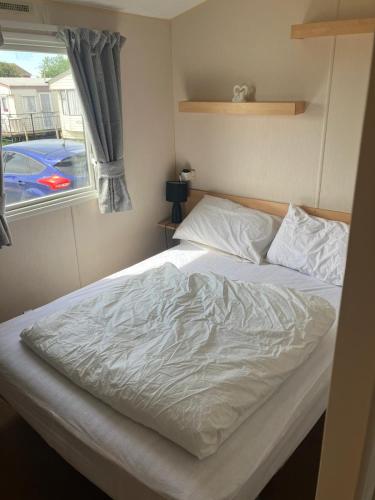 a bed in a small room with a window at Julie's in Ingoldmells