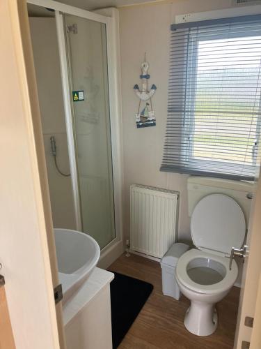 a bathroom with a white toilet and a sink at Julie's in Ingoldmells