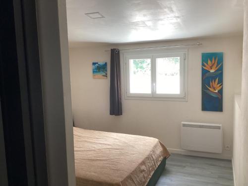 a bedroom with a bed and a window at Celimène in Canet-en-Roussillon
