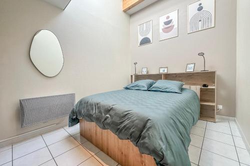 a bedroom with a bed and a mirror on the wall at Cocon en Chartreuse in Voreppe