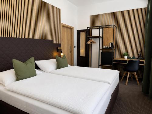 a hotel room with a bed and a desk at Zelena Ratolest in České Budějovice