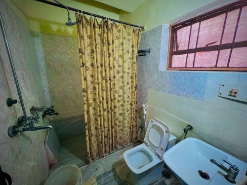 a bathroom with a sink and a toilet and a shower at Gaurav Boarding House in Mathura