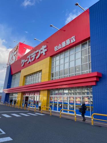 a person walking in front of a store at Orange Stay Matsuyama in Matsuyama