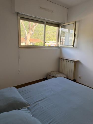 a bedroom with a bed and a window at Appartement sagone in Coggia