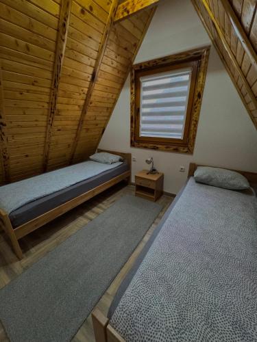 two beds in a room with a window at Vlasic Odmor - Villa Krajina III in Vlasic
