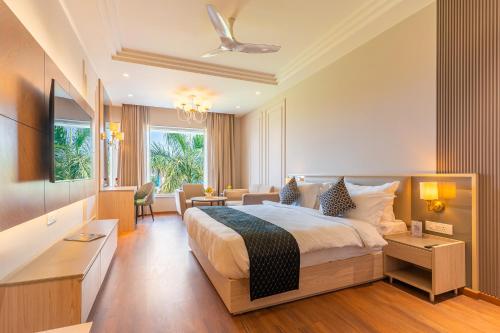 a bedroom with a large bed and a living room at Ranveer The Garden Resort in Haldwāni