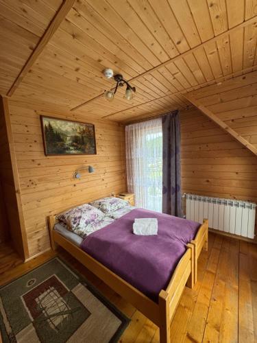 a bedroom with a bed in a wooden room at DW u Rafała i Joanny in Białka Tatrzańska