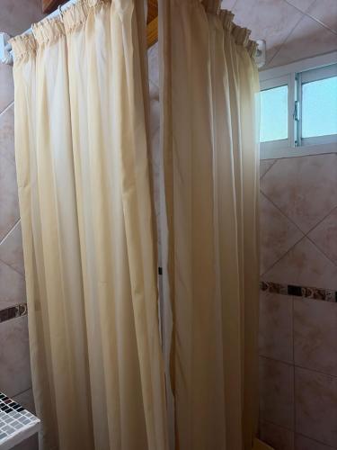 a shower curtain in a bathroom with a window at cabañas los juanes in Tres Arroyos