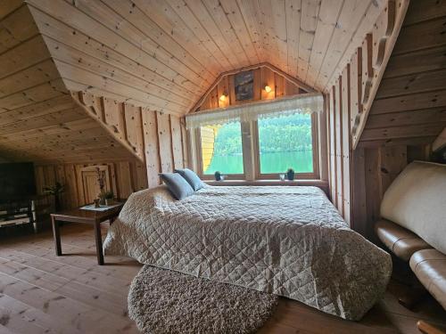 a bedroom with a bed in a wooden cabin at Huset ved Dalsfjorden in Helle