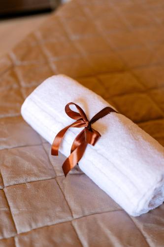 a towel with a bow on top of a bed at Masseria La Vecchia Lamia in San Vito dei Normanni