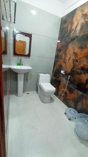 a bathroom with a toilet and a sink at Bluemoon Stay in Uttarkāshi