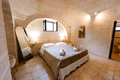 a bedroom with a bed in a room with a window at Masseria La Vecchia Lamia in San Vito dei Normanni