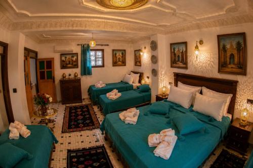 a bedroom with three green beds with towels on them at Riad T-A-J Fès Crown in Fez