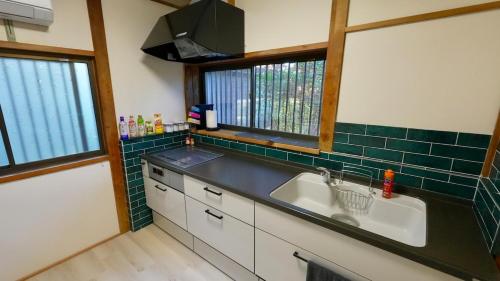 a kitchen with a sink and a window at Serene Hill Retreat in Nakatsugawa