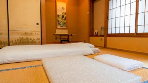 a room with two white rugs on the floor at Serene Hill Retreat in Nakatsugawa
