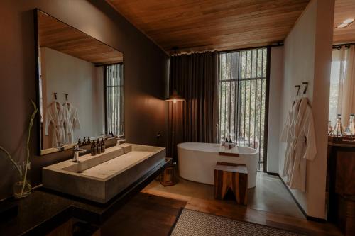 a bathroom with a large tub and a large window at Rodavento Valle de Bravo in Valle de Bravo