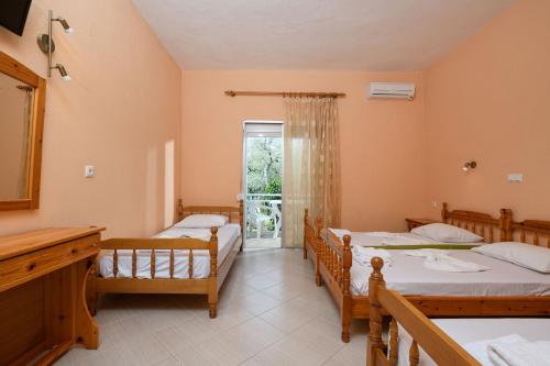 a bedroom with three beds and a window at Qyra Studios in Skala Rachoniou