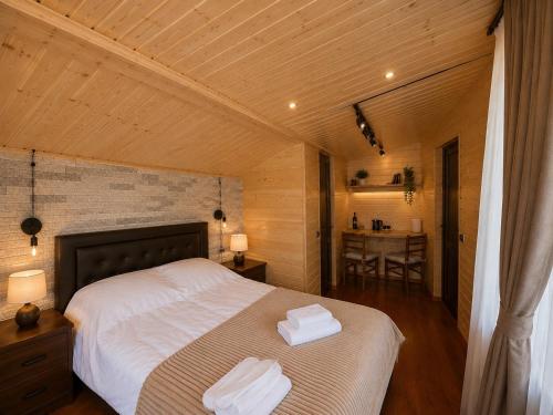a bedroom with a bed with two towels on it at Tamila Guest House in Kazbegi