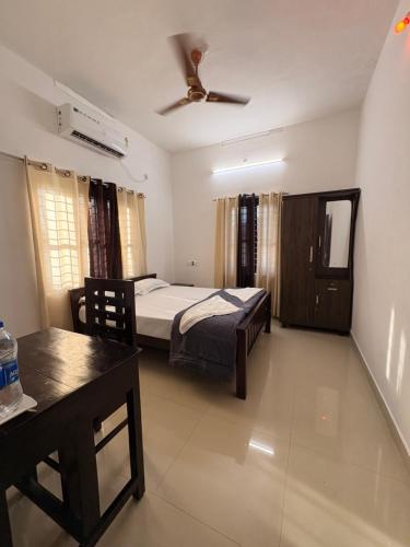 a bedroom with a bed and a ceiling fan at Baylio Homestay in Kappil