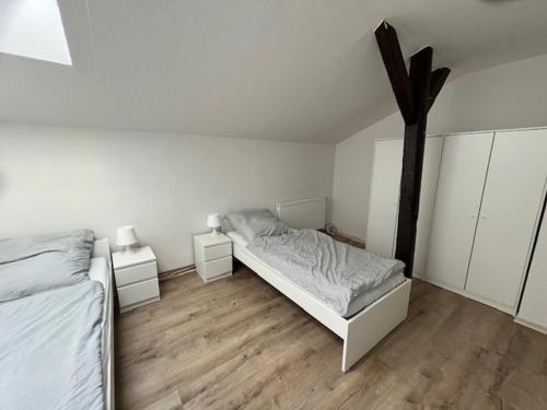 a white bedroom with a bed and two night stands at Helles 2 Bettzimmer in Jerrishoe