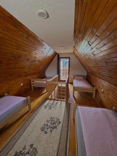 a room with two beds and a wooden ceiling at Vlasic Odmor - Villa Krajina II in Vlasic
