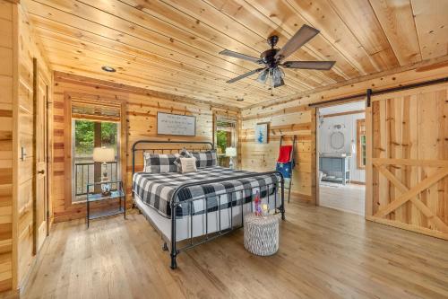 a bedroom with a bed and a ceiling fan at Twilight Pines - Dreamy Cabin w Hot Tub & optional Kids Loft in Broken Bow
