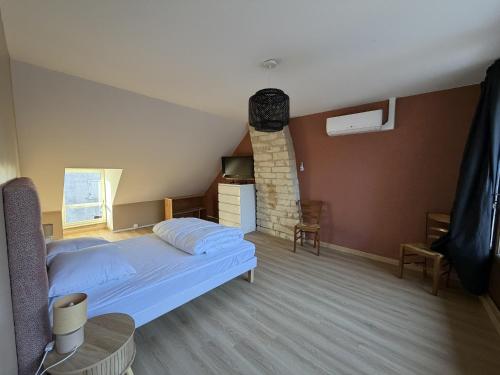a bedroom with a bed and a brick wall at Les Remparts T2 et T3 2 Etoiles in La Roche-Posay